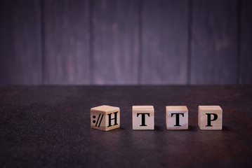 The word http on wooden cubes, on a dark background, light wooden cubes signs, symbols signs, business office, site content
