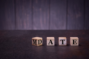 The word date mate on wooden cubes, on a dark background, light wooden cubes signs, symbols signs,...