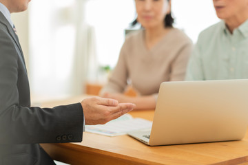 中年夫婦に説明するビジネスマン