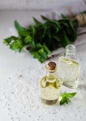 Natural Mint Essential Oil in a Glass Bottle with Fresh Mint Leaves