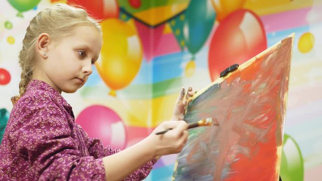 girl draws on the easel.close-up