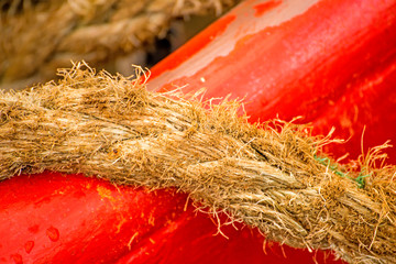 Mooring line of a trawler on a red ship hull