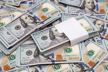 One hundred dollar bills on the table as background