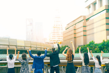 Obraz premium View from back global business teamwork raise hands up,have space for idea