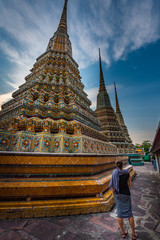 Fototapeta premium Woman Tourist admires Wat Pho Temple Bangkok Thailand