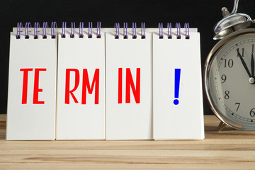 Ein Wecker und ein Organizer mit dem Wort Termin
