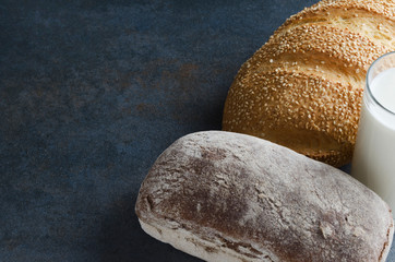Homemade delicious loaves of bread,glass of milk.Tasty snack time.Rustic mood.Copy space for text