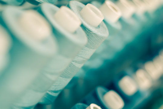 Blue Thread Spools / Long rows of blue thread spools filling the frame blur background and foreground