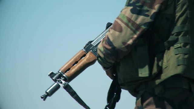 An army soldier holds a gun in his hand (AKM)