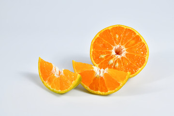 Half and slice of orange on white background.