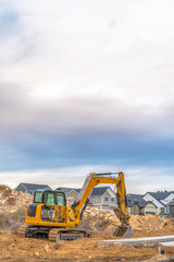 Obraz premium Excavator against homes and sky in Utah Valley