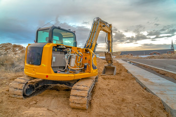 Excavator with Utah Valley church in background