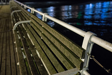 Close up of the wooden bench seats on Cromer pier captured during the hours of darkness