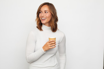 portrait of happy young woman with to go cup of coffee