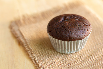 Chocolate cupcake on brown crumpled paper with copy space.