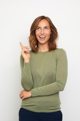 portrait of young woman pointing at blank copyspace