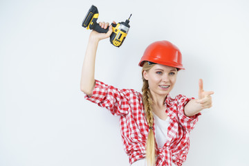 Woman wearing helmet using drill