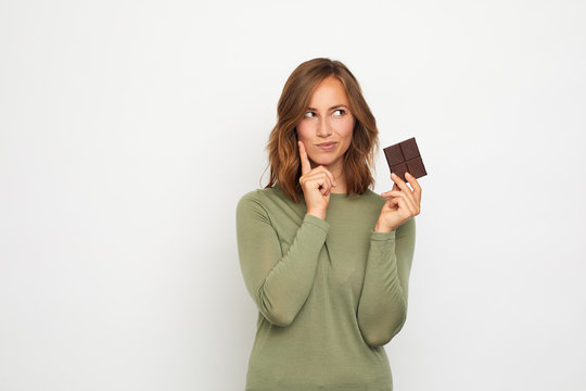 portrait of young woman with chocolate thinking