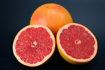 Naklejka na ściany i meble Cut citrus fruit grapefruit on a dark background