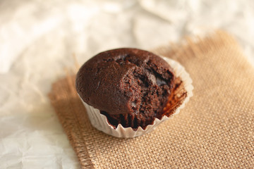 Chocolate cupcake on brown crumpled paper with copy space.