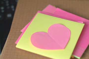 pink paper cut of heart sharp with sticky note.