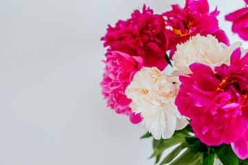 Frame of beautiful fuchsia and white peony flower bouquet on the white background. Closeup, flatlay style.