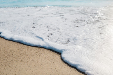 Beautiful bue sea with foam and yellow sand beach