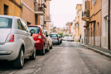 Obraz na płótnie Canvas Cars Parked On Street In European City In Summer Day