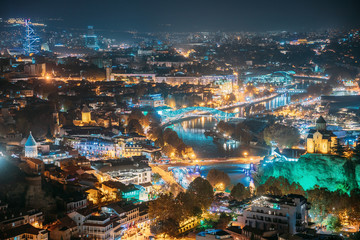 Tbilisi, Georgia. Top View Of Famous Landmarks In Night Illuminations. Georgian Capital Skyline Cityscape