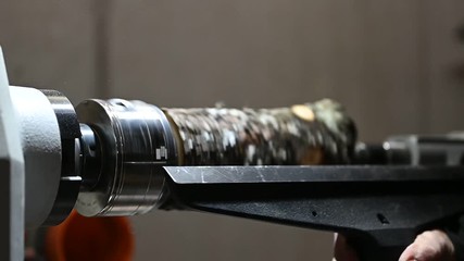 rotating piece of wood on turnery machine prepared with chisel