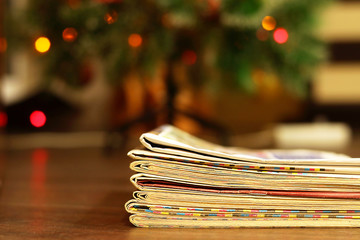 Stack of Newspapers and Magazines under Christmas Tree with Christmas Lights. Business Holiday Card...