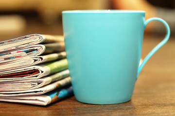 Stack of newspapers and cup of tea. Daily papers stacked in pile and morning coffee, concept for reading paper media during breakfast 