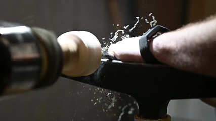 man cuts wood with chisel with flying sawdust and shavings