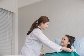 Fototapeta premium Hands woman doctor using blanket to her female patient in hospital room,Doctor giving a consultation and encouragement to patient
