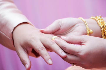 The woman wears a wedding ring on man's hand