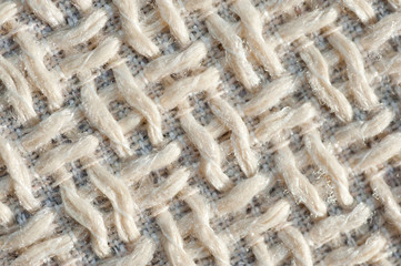 Textured fabric mat with woven wool beige yarn closeup shot..
