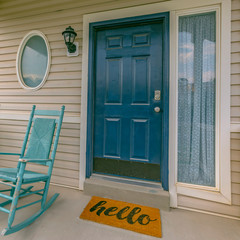 Green front door of a home with yellow doormat