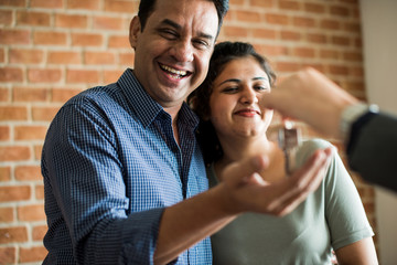 Cheerful couple with keys to their new home