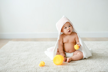 Baby in a bath towel with rubber ducks