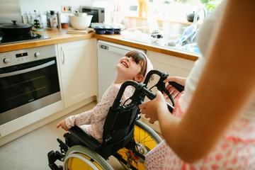 Girl helping her sister in a wheelchair