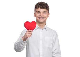 Happy Valentines Day. Cute young Teen Boy in Love with Red plush Heart in his hands. Smiling Child looking at camera, isolated on white background.