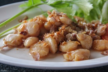 Fried scallops with garlic and pepper in white dish