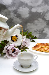 tea and pancakes on the background of beautiful pions.