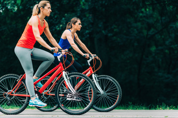 Fototapeta na wymiar Two Women Cycling Together