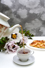 tea and pancakes on the background of beautiful pions.