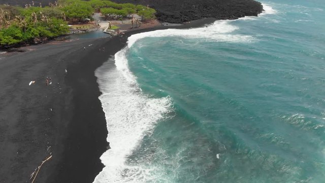 aerial footage of pohoiki bay. ( Isaac hale park. puna Hawaii. black sand beach on the east side of the big island of Hawaii. drone footage.  cooled lava in the background.