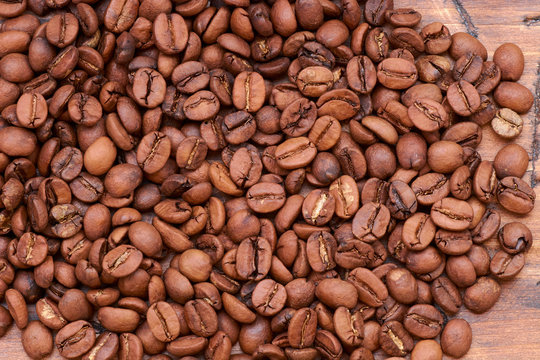 coffee beans on a wooden background scattered © vinkirill