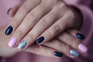Obraz na płótnie Canvas Gorgeous manicure, pastel tender pink color nail polish, closeup photo. Female hands over simple background