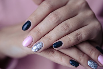 Gorgeous manicure, pastel tender pink color nail polish, closeup photo. Female hands over simple background