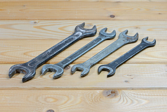 Old used wrenches on a wooden background. Vintage spanners